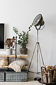 Vintage metal crates, wooden shelves, industrial lamp and basket with firewood in the living room