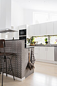 White, open kitchen with kitchen island in an industrial look