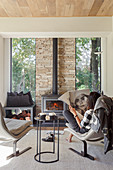 Woman reading the newspaper in front of a fireplace in a bright living room