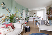 Natural white sofas and wallpaper with botanical design in an open living room