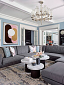 U-shaped sectional sofa set and round tables in the living room with white coffered ceiling and light blue walls