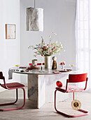 Red chairs around marble table with bouquet of flowers