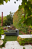 Terrasse und Garten mit Sitzgruppe und Mauer mit Wildem Wein