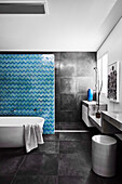 Schwarz gefliestes Badezimmer, Trennwand mit marokkanischen Fliesen vor dem Duschbereich