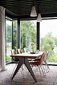 Dining table and modern chairs in dining room with floor-to-ceiling windows