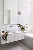 Badezimmer mit weißen Wandlfiesen, Waschtisch aus Carrara-Marmor und Terrazzoboden