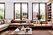 Eingebaute Sofa und Couchtisch vor raumhohen Fenstern