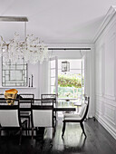 Dining table with chairs, lavish chandelier above