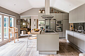 A fitted kitchen without handles, a kitchen island with a Corian worktop and a breakfast bar