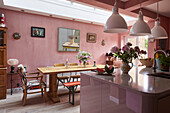 The bright and spacious kitchen painted in pink tones, with a selection of artwork and Silestone quartz counter tops