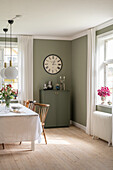 Classic dining room with walls in sage in an old building with plank wooden flooring