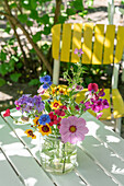 Bunter Blumenstrauß mit Cosmea und Phlox auf dem Gartentisch