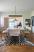 Oval dining table with classic chairs on zebra skin rug in dining room