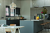 Kücheninsel mit Frühstückstheke und Barhocker in offener Küche einer Loft-Wohnung