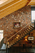 Treppe in der Lounge mit Holzdecke und Natursteinwand