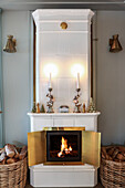 Fire burning in white tiled stove decorated for Christmas