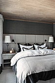 Double bed with upholstered panel headboard in bedroom