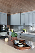 Custom kitchen cabinets with light grey fronts and kitchen island in foreground