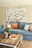 Abstract painting behind blue sofa in maritime living room