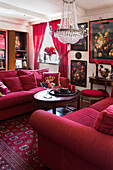 Sofagruppe mit Kissen, Teppiche und Vorhänge in Rot im Wohnzimmer