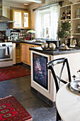 Eclectic kitchen with paintings and sculptures on windowsill