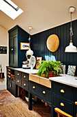 Custom cabinets and stone sink in kitchen with herringbone brick floor