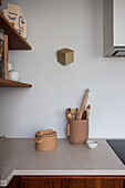 Wall lamp in cube design and rustic container of kitchen utensils