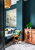 Blick ins blaue Schlafzimmer mit Doppelbett, Wandbehang, Stuhl und Kommode
