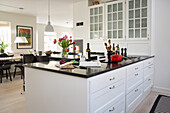 Weiße Kücheninsel mit Arbeitsplatte aus schwarzem Granit