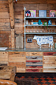 Küchenunterschränke aus Holz und Regal vor Bretterwand
