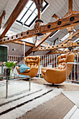 Comfortable leather armchairs and wooden roof structure on mezzanine