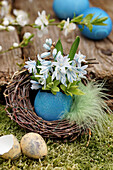 Small bouquet of Puschkinia flowers in a turquoise vase in an Easter nest