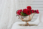 Silver sauce boat with red rose petals