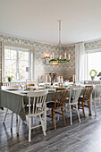 Festively set table in dining room with vintage-style wallpaper