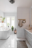 White bathroom with washstand and freestanding bathtub