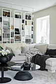 White living room with shelving, sofa set and black table set