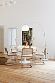 Dining area with white classic table, light cantilever chairs and arc lamp