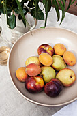 Schale mit Früchten auf gedecktem Tisch