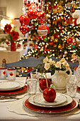 Weihnachtstisch mit Liebasapfel, im Hintergrund Weihnachtsbaum