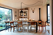 Long dining table with chairs, Christmas decorations and antlers on the wall