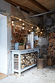 Barn with decorated workbench, fairy lights and firewood