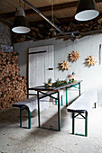 Tall table set and star decoration in front of wood pile in barn