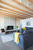 Grey velvet sofa in the modern living room with concrete fireplace