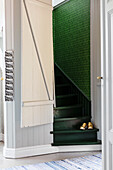 Stairwell with narrow, green-painted staircase and green wallpaper