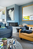 Blue and white sofa and buff leather armchair in living room
