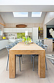 Kitchen and dining area with wooden table and classic chairs under skylight