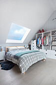 Double bed and wardrobe in bedroom with sloping ceiling