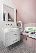 Washstand and bathtub in bathroom with pink wall