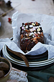 Homemade chocolate cake with nuts and sprinkles on a plate