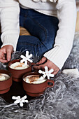 Heiße Schokolade mit Marshmallows und Schneeflocken-Dekoration auf flauschiger Decke